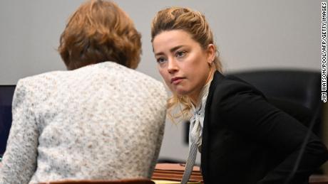 Amber Heard speaks to her attorney at the Fairfax County Circuit Courthouse on Tuesday.