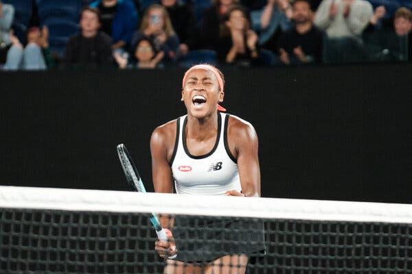 Coco Gauff, holding a racket in her right hand and clenching her left fist, celebrating during her match against Emma Raducanu.
