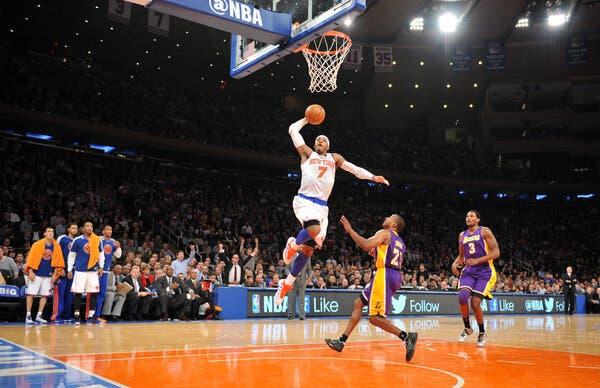 Carmelo Anthony, wearing a white Knicks jersey with the No. 7, going up for a dunk with his right hand.